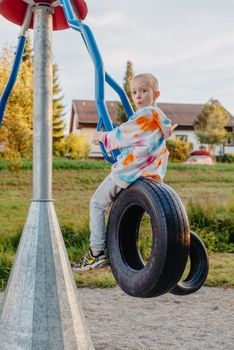 Funny cute happy baby playing on the playground. The emotion of happiness, fun, joy. Smile of a child. boy playing on the playground.