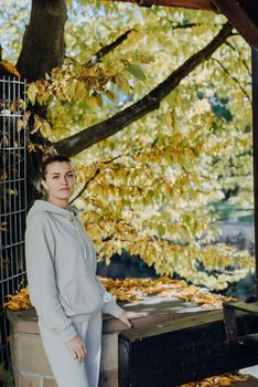 Beautiful elegant woman standing in a park in autumn. autumn yellow leaves. Portrait of joyful woman in park during fall. Happy girl with yellow leaves outdoor. Beauty Romantic Girl Outdoors enjoying nature. Beautiful autumn model with waving glow hair.Sun light on sunset.Warm toned art work. Portrait of romantic female