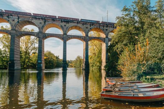 Railway Bridge with river in Bietigheim-Bissingen, Germany. Autumn. Railway viaduct over the Enz River, built in 1853 by Karl von Etzel on a sunny summer day. Bietigheim-Bissingen, Germany. Old viaduct in Bietigheim reflected in the river. Baden-Wurttemberg, Germany. Train passing a train bridge on a cloudy day in Germany