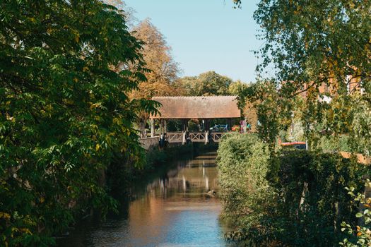 A wooden bridge in the park with and autumn colors of Bietigheim-Bissingen, Germany. Europe. Autumn landscape in nature. Autumn colors in the forest. autumn view with wooden bridge over stream in the park in autumn season