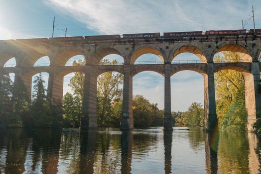 Railway Bridge with river in Bietigheim-Bissingen, Germany. Autumn. Railway viaduct over the Enz River, built in 1853 by Karl von Etzel on a sunny summer day. Bietigheim-Bissingen, Germany. Old viaduct in Bietigheim reflected in the river. Baden-Wurttemberg, Germany. Train passing a train bridge on a cloudy day in Germany