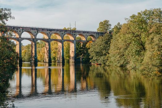 Railway Bridge with river in Bietigheim-Bissingen, Germany. Autumn. Railway viaduct over the Enz River, built in 1853 by Karl von Etzel on a sunny summer day. Bietigheim-Bissingen, Germany. Old viaduct in Bietigheim reflected in the river. Baden-Wurttemberg, Germany. Train passing a train bridge on a cloudy day in Germany