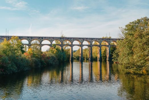 Railway Bridge with river in Bietigheim-Bissingen, Germany. Autumn. Railway viaduct over the Enz River, built in 1853 by Karl von Etzel on a sunny summer day. Bietigheim-Bissingen, Germany. Old viaduct in Bietigheim reflected in the river. Baden-Wurttemberg, Germany. Train passing a train bridge on a cloudy day in Germany