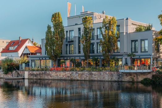 River on sunset. Townhouses buildings and multi-floor home at waterfront. Sunset on River in city. Suburb houses and residential building near river in Europe. House in nature on shore on sunset.