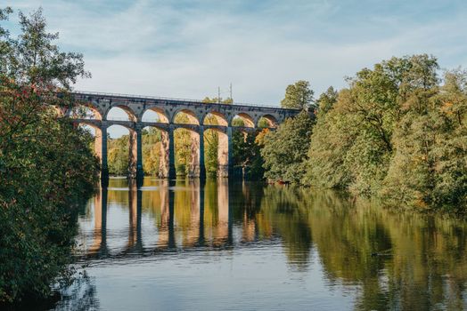 Railway Bridge with river in Bietigheim-Bissingen, Germany. Autumn. Railway viaduct over the Enz River, built in 1853 by Karl von Etzel on a sunny summer day. Bietigheim-Bissingen, Germany. Old viaduct in Bietigheim reflected in the river. Baden-Wurttemberg, Germany. Train passing a train bridge on a cloudy day in Germany