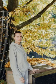 Beautiful elegant woman standing in a park in autumn. autumn yellow leaves. Portrait of joyful woman in park during fall. Happy girl with yellow leaves outdoor. Beauty Romantic Girl Outdoors enjoying nature. Beautiful autumn model with waving glow hair.Sun light on sunset.Warm toned art work. Portrait of romantic female