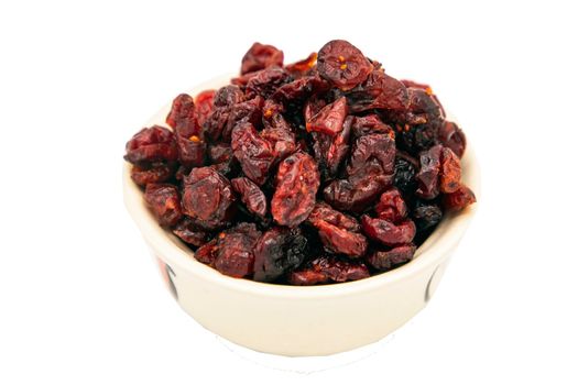 Tasty red cranberry (dried) in white cup isolated on white background with clipping path. Selective focus.