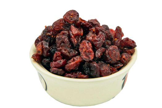 Tasty red cranberry (dried) in white cup isolated on white background with clipping path. Selective focus.