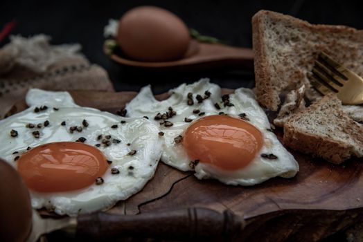 Two fried eggs with toast for healthy breakfast on beautiful wooden background, Nutrition concept, Oblique view from the top.