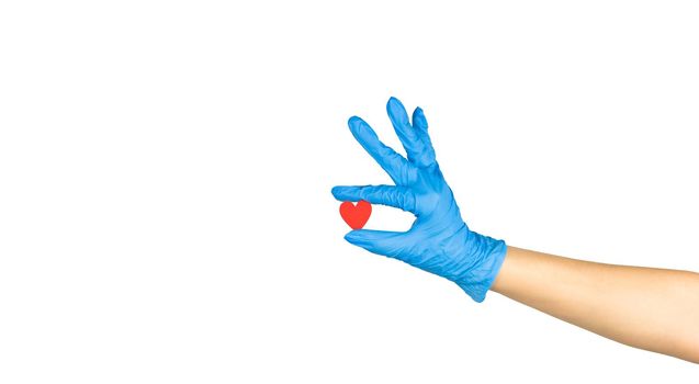hand in blue medicine glove holding wooden red heart with two fingers showing it isolated on white background