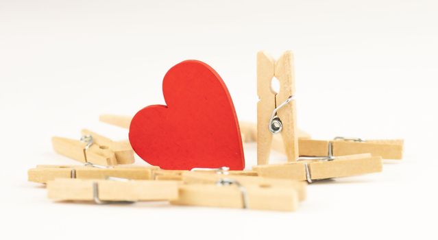 concept composition of love relationships outstanding. clothespins and red wooden heart.