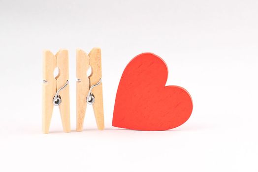 concept composition of love relationships outstanding. clothespins and red wooden heart.