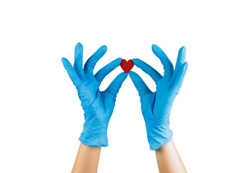 hand in blue medicine glove holding wooden red heart with two fingers showing it