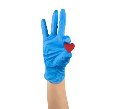hand in blue medicine glove holding wooden red heart with two fingers showing it