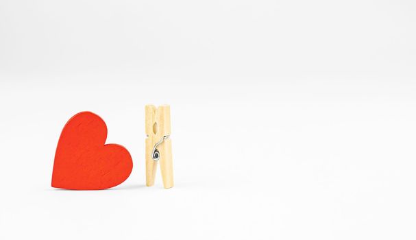 concept composition of love relationships outstanding. clothespins and red wooden heart.
