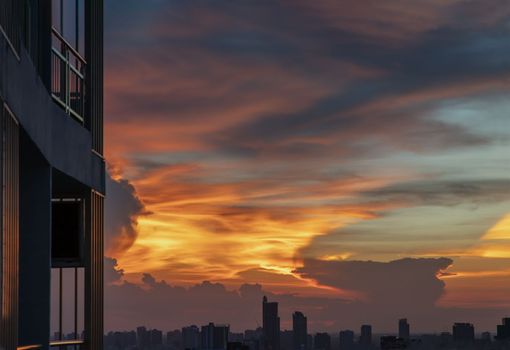 Beautiful sunset sky above clouds with skyscraper evening time with residence balcony and dramatic light. Copy space, No focus, specifically.