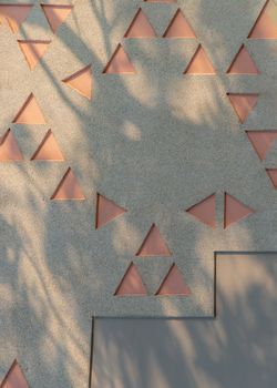 Exterior wall decoration with geometric elements and sunlight. Wall for background.