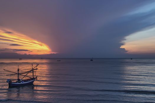 Thai fishing boat used as a vehicle for finding fish in the during beautiful twilight in the sea. No focus, specifically.