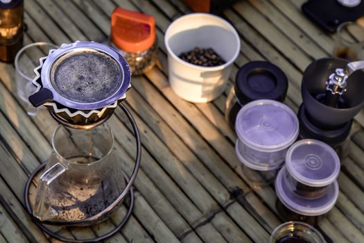 Kit for drip coffee with cup on a bamboo table with coffee beans. Selective focus.