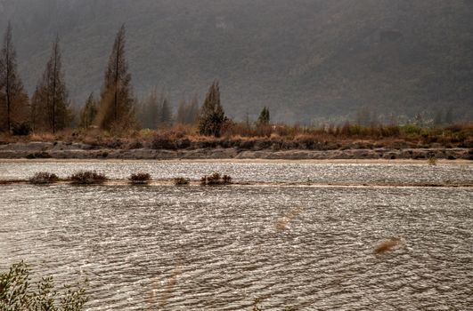 Mountain landscape. A great mountain is surrounded river. No focus, specifically.