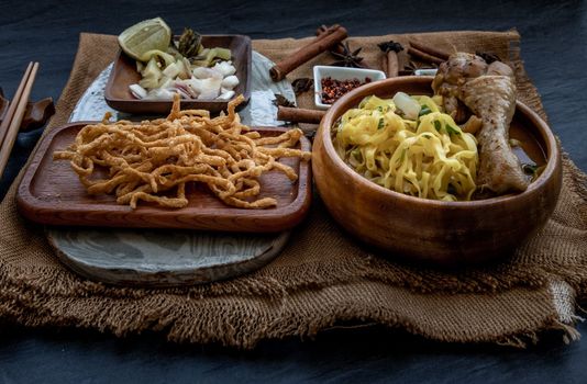 Northern Style Curried Noodle Soup with coconut milk (Khao soi), Traditional of Northern Thai cuisine, Oblique view from the top.