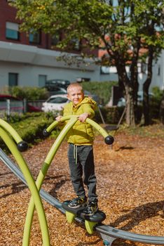 Funny cute happy baby playing on the playground. The emotion of happiness, fun, joy. Smile of a child. boy playing on the playground.