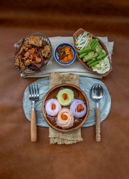 Rice noodles with spicy pork sauce or Nam ngiao Rice Noodle (Traditional Northern Thai Cuisine). Nam ngiao has a characteristic spicy and tangy flavor Served with vegetable. Thai spicy food.