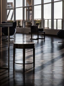 Bangkok, Thailand - Jan 10, 2022 : Wood table small inside in common area with morning sunlight shines through windows at common area. Beautiful light and shadow from the glass windows, Selective focus.