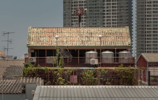 Urban residential old building with 3 stainless steel water tanks for heating water on the balcony. Selective focus.