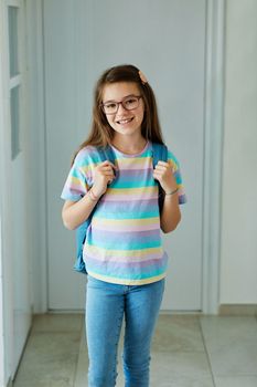 Portriat of a young teen school girl with backpack ready for school at home