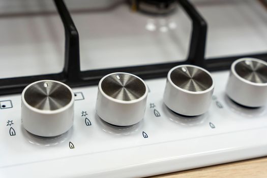 the handle for turning on the burner of a home kitchen stove. close-up. Home gas stove. The job in the kitchen. Control knobs of electric stove close-up