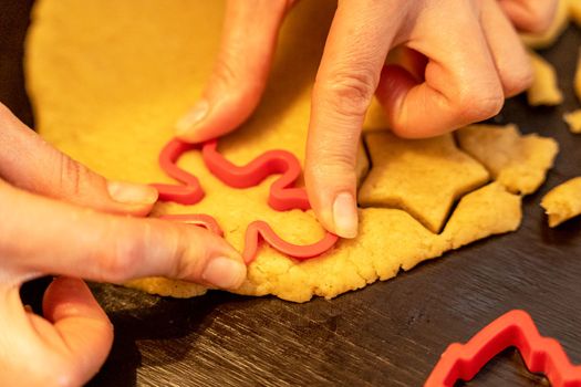 Dough, cookie cutters, mold. Dough for preparing cookies. molds on table. hands making cookies. cutting the dough with the molding trim.