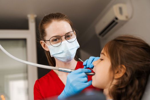 Dental drill. Child dentist drilling teeth of kid girl in dentistry clinic. Dental filling for child patient