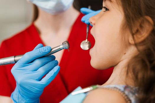 Dental drill close-up. Child dentist drilling teeth of kid girl in dentistry clinic. Teeth treatment. Dental filling for child patient