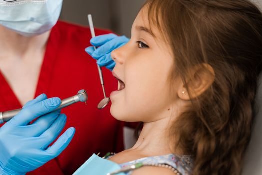 Dental drill close-up. Child dentist drilling teeth of kid girl in dentistry clinic. Teeth treatment. Dental filling for child patient