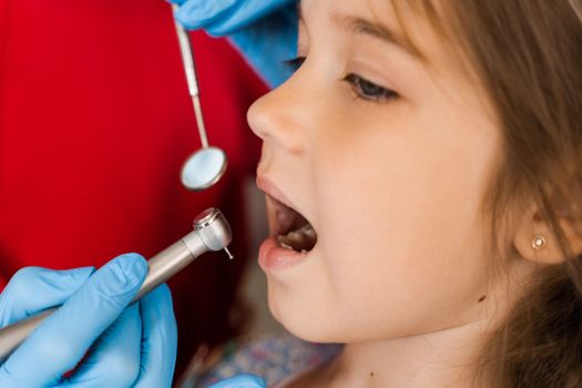 Dental drill close-up. Child dentist drilling teeth of kid girl in dentistry clinic. Teeth treatment. Dental filling for child patient