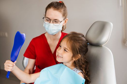 Children dentistry. Dentist and child patient. Consultation with child dentist at dentistry. Teeth treatment. Child looking in the mirror at the dentist. Happy child patient of dentistry