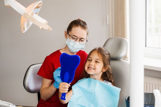 Children dentistry. Dentist and child patient. Consultation with child dentist at dentistry. Teeth treatment. Child looking in the mirror at the dentist. Happy child patient of dentistry
