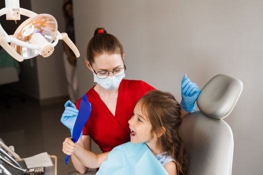 Children dentistry. Dentist and child patient. Consultation with child dentist at dentistry. Teeth treatment. Child looking in the mirror at the dentist. Happy child patient of dentistry