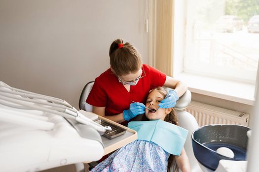 Cheerful child girl smiling at dentists consultation in dentistry. Dental diseases. Consultation with pediatric dentist for treatment of toothache in child