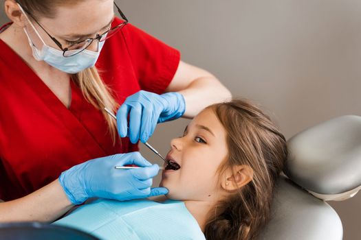 Pediatric dentist and cheerful girl child smiling in dentistry. Child smiles at the consultation with dentist. Creative advertising for dentistry