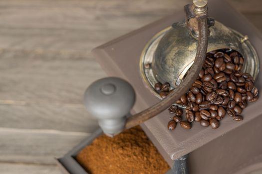 antique coffee grinder with coffee beans and ground coffee