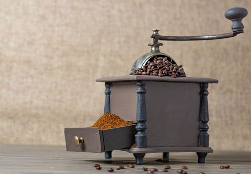 antique coffee grinder with coffee beans and ground coffee