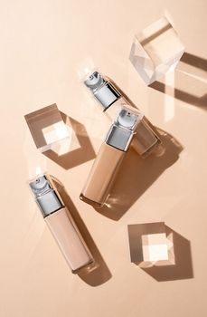 luxury glass bottles with foundation base beauty make up product , mockup design with glass prisms and podiums on beige background