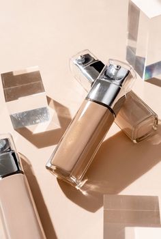 luxury glass bottles with foundation base beauty make up product , mockup design with glass prisms and podiums on beige background