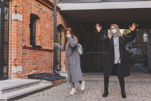 Young pretty girls friends having fun outdoor in autumn evening in city laughing and going crazy on the street - friendship and funny people