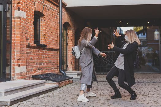 Young pretty girls friends having fun outdoor in autumn evening in city laughing and going crazy on the street - friendship and funny people