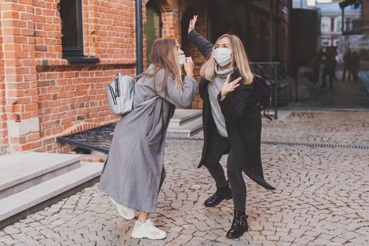 Young pretty girls friends having fun outdoor in autumn evening in city laughing and going crazy on the street - friendship and funny people