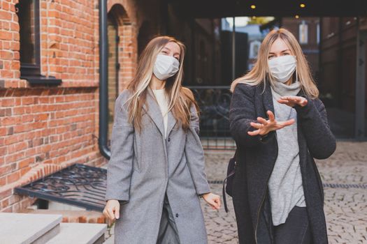 Young pretty girls friends having fun outdoor in autumn evening in city laughing and going crazy on the street - friendship and funny people