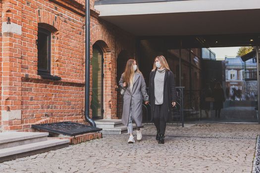 Young pretty girls friends having fun outdoor in autumn evening in city laughing and going crazy on the street - friendship and funny people